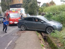 Sebuah Mobil Terperosok di Parit Dekat Kantor Dinsos Kuningan